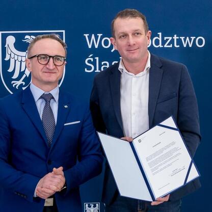 Grzegorz Boski, wicemarszałek Województwa Śląskiego, wręcza beneficjentom listy gratulacyjne. (wygenerowano przez AI)