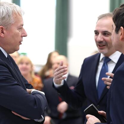 Trzech mężczyzn w strojach formalnych dyskutuje na konferencji o demografii i strategiach do walki z depopulacją i wyludnianiem miast w Śląsku. (wygenerowano przez AI)