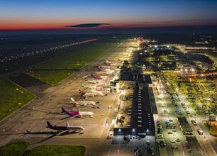 Katowice Airport, oświetlone terminaly i lotniskowe drogi, widoczne wczesnym wieczorem. (wygenerowano przez AI)
