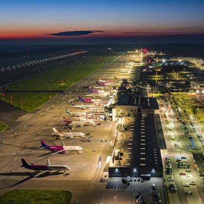 Katowice Airport, oświetlone terminaly i lotniskowe drogi, widoczne wczesnym wieczorem. (wygenerowano przez AI)