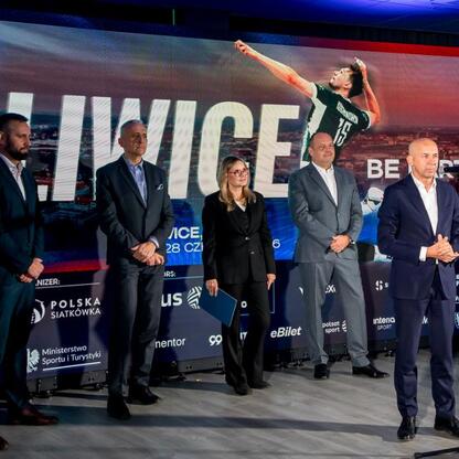 Wicemarszałek Województwa Śląskiego Leszek Pietraszek wraz z uczestnikami konferencji prasowej na tle reklamy Volleyball Nations League w Gliwicach. (wygenerowano przez AI)