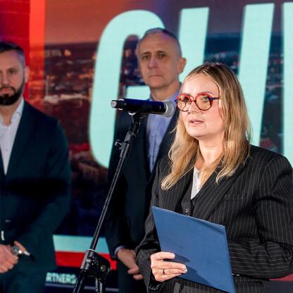 Wicemarszałek Województwa Śląskiego Leszek Pietraszek przemawia na podium podczas imprezy sportowej w Gliwicach. (wygenerowano przez AI)
