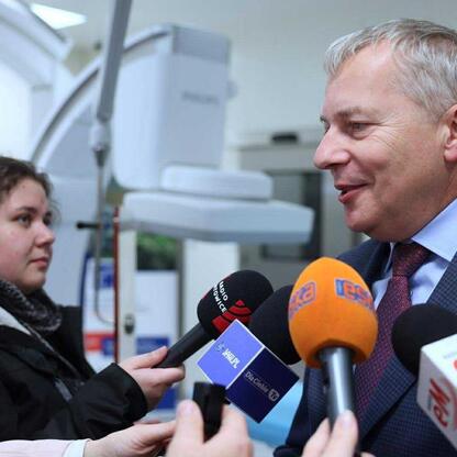Marszałek Wojciech Saługa w rozmowie z dziennikarzami przedstawia nową salę hybrydową w Wojewódzkim Szpitalu Specjalistycznym im. św. Barbary w Sosnowcu. (wygenerowano przez AI)