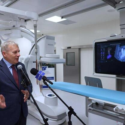 Marszałek Wojciech Saługa prezentuje nowe sprzęty medyczne w nowoczesnej sali hybrydowej. (wygenerowano przez AI)