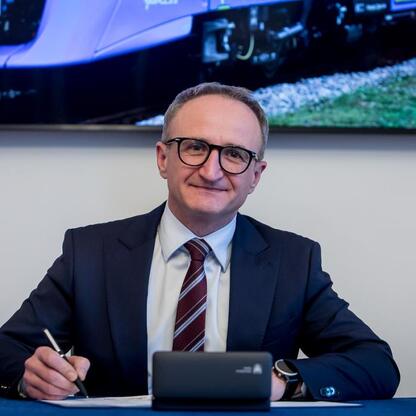 Grzegorz Boski, wicemarszałek Województwa Śląskiego, podpisuje dokument na ceremonii zakupu nowych pociągów dla Kolei Śląskich. (wygenerowano przez AI)