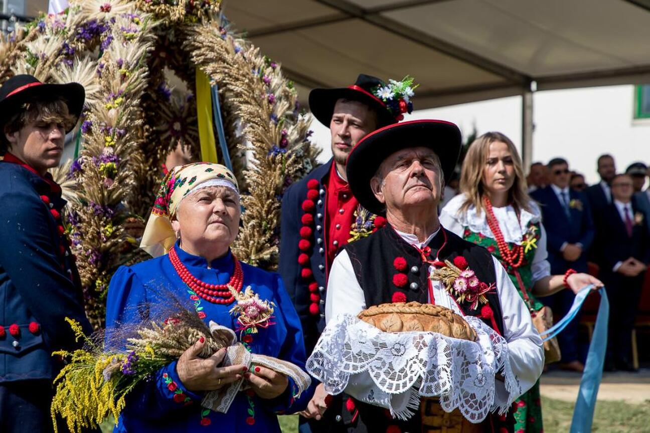 Fotografia przedstawia kolorowe festyny ludowe w tradycyjnych polskich strojach, symbolizujące kulturę i dziedzictwo regionu Śląska. (wygenerowano przez AI)