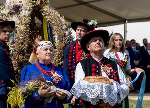 Fotografia przedstawia kolorowe festyny ludowe w tradycyjnych polskich strojach, symbolizujące kulturę i dziedzictwo regionu Śląska. (wygenerowano przez AI)