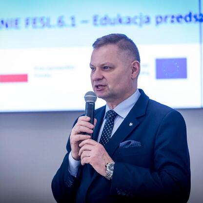 Rafał Adamczyk, członek zarządu województwa, przemawia na konferencji o finansowaniu edukacji przedszkolnej. (wygenerowano przez AI)
