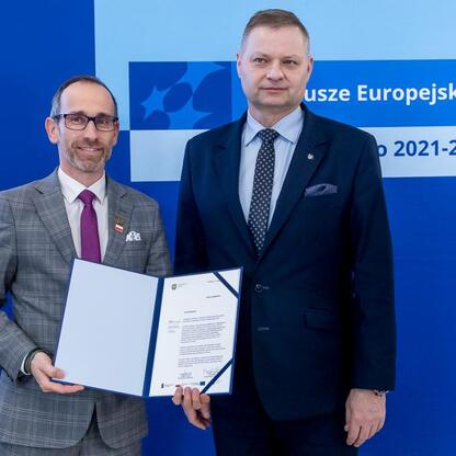 Rafał Adamczyk i Marcin Ryś prezentują dokumenty w ramach programu Fundusze Europejskie 2021-2027 na Śląsku. (wygenerowano przez AI)