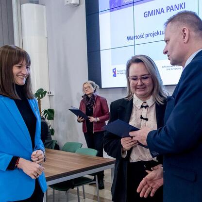 Rafał Adamczyk, członek Zarządu Województwa Śląskiego, wręcza listy gratulacyjne uczestnikom ceremonii otrzymania funduszy dla przedszkoli. (wygenerowano przez AI)