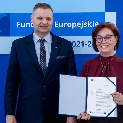 Rafał Adamczyk, Członek Zarządu Województwa Śląskiego, wręcza listy gratulacyjne projektom otrzymanym dofinansowaniu w ramach programu Funduszy Europejskich 2021-2027. (wygenerowano przez AI)