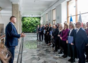 Rafał Adamczyk, członek Zarządu Województwa Śląskiego, wręcza listy gratulacyjne uczestnikom projektów edukacyjnych. (wygenerowano przez AI)