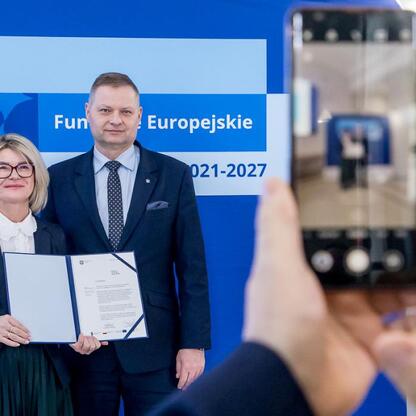 Rafał Adamczyk, członek Zarządu Województwa Śląskiego, wręcza listy gratulacyjne w ramach programu Funduszy Europejskich 2021-2027. (wygenerowano przez AI)