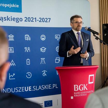Wicemarszałek Województwa Śląskiego Leszek Pietraszek przemawia na podium podczas briefingu prasowego o nowych pożyczkach rozwojowych dla przedsiębiorców. (wygenerowano przez AI)