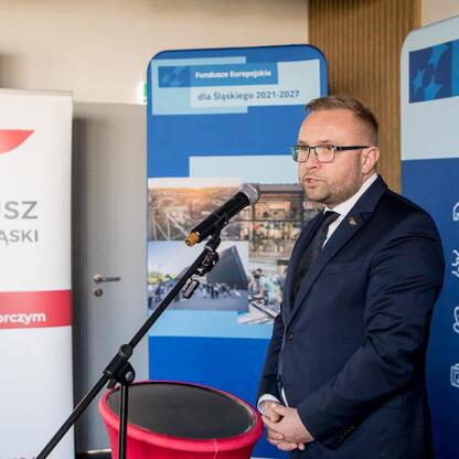 Wicemarszałek Województwa Śląskiego Leszek Pietraszek przemawia na briefingu prasowym o finansowaniu dla małych i średnich przedsiębiorstw w ramach programu Fundusze Europejskie dla Śląska 2021-2027. (wygenerowano przez AI)