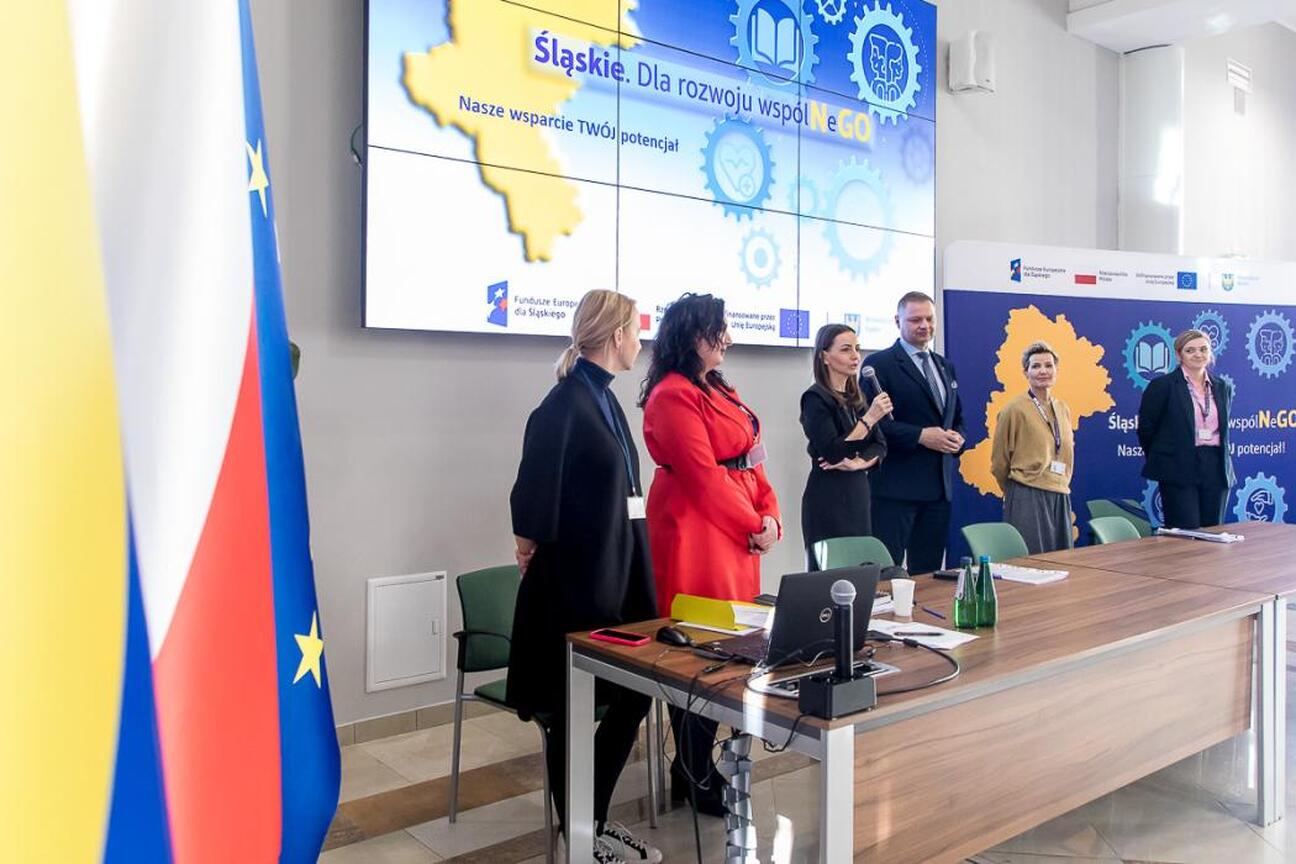 Grupa ludzi w formalnym uroczystości województwa śląskiego, zgłaszająca wnioski o granty. (wygenerowano przez AI)