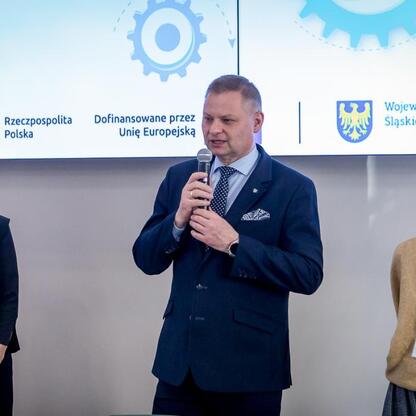 Rafał Adamczyk, członek Zarządu Województwa Śląskiego, prowadzi spotkanie informacyjne o grantach w Śląskim. (wygenerowano przez AI)