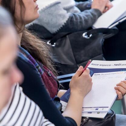 Grupa ludzi uczestniczy w spotkaniu informacyjnym o grantach dla organizacji społecznych województwa śląskiego. (wygenerowano przez AI)
