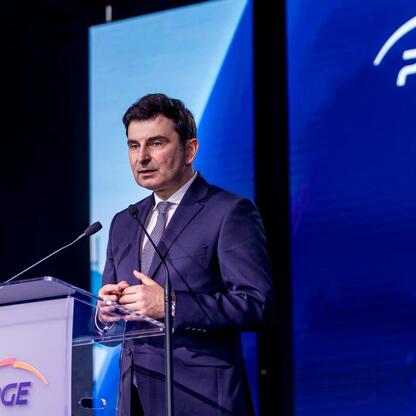 Mężczyzna przemawia na podium podczas konferencji o budowie nowych elektrowni gazowych w Rybniku i Gryfino. (wygenerowano przez AI)