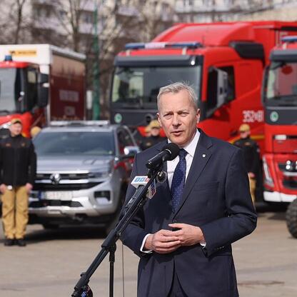 Marszałek Wojciech Saługa przemawia na uroczystości dostawy sprzętu strażackiego w Katowicach. (wygenerowano przez AI)