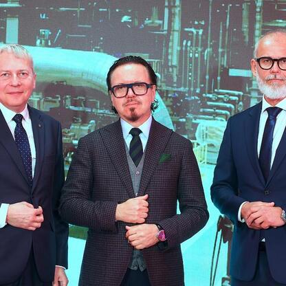 Trzech mężczyzn w formalnym stroju przedstawiających plan inwestycyjny TAURON dla Śląska. (wygenerowano przez AI)