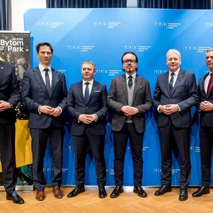 Marszałek Województwa Śląskiego Wojciech Saługa wraz z uczestnikami spotkania przedstawia logo i nazwę TFS Towarzystwo Finansowe Silesia, podkreślając rozwój Silesia Bytom Park. (wygenerowano przez AI)