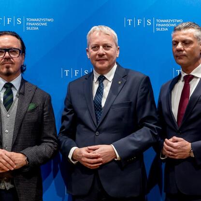 Trzech mężczyzn w garniturach przed logo i nazwą TFS Towarzystwo Finansowe Silesia. (wygenerowano przez AI)