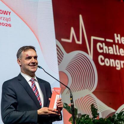 Laureat IX Zdrowy Samorząd odbiera nagrodę na XI Kongresie Wyzwań Zdrowotnych. (wygenerowano przez AI)
