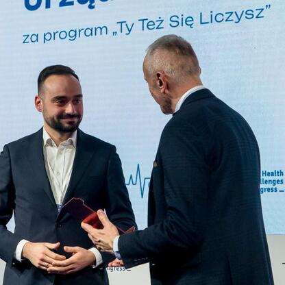 Wicemarszałek Województwa Śląskiego Leszek Pietraszak prezentuje nagrodę na Kongresie Wyzwań Zdrowotnych. (wygenerowano przez AI)