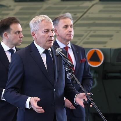 Marszałek Wojciech Saługa prowadzi konferencję prasową ws. wsparcia KSSE dla inwestycji w Rosomak S.A. (wygenerowano przez AI)