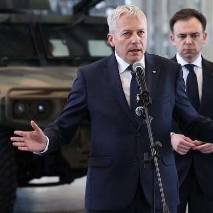 Marszałek Wojciech Saługa przemawia na konferencji prasowej wsparcie dla inwestycji w Rosomak S.A. (wygenerowano przez AI)