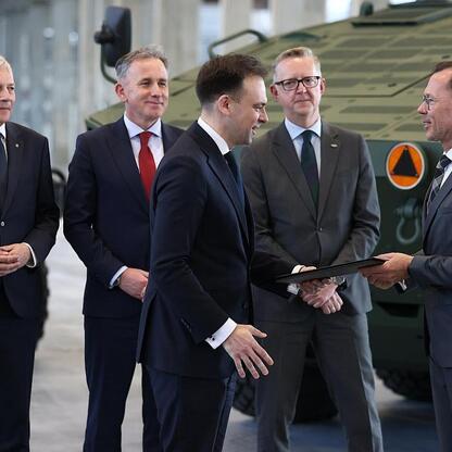 Marszałek Wojciech Saługa i jego współpracownicy podczas konferencji prasowej wsparcia dla inwestycji w Rosomak S.A. w Siemianowicach Śląskich. (wygenerowano przez AI)