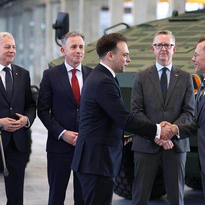 Marszałek Wojciech Saługa i jego współpracownicy przedstawiają inwestycję w modernizację zakładu Rosomak S.A. w Siemianowicach Śląskich. (wygenerowano przez AI)