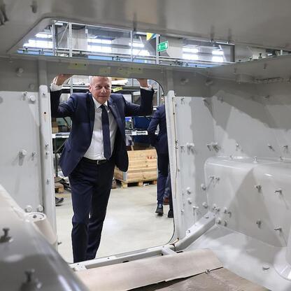 Marszałek Wojciech Saługa inspirowa na montażu pojazdów Legwan 4x4 w fabryce Rosomak S.A. w Siemianowicach Śląskich. (wygenerowano przez AI)