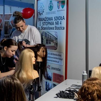 Festiwal Zawodowca w Bielsku-Białej: student demonstruje fryzjerkę na manekinie, uczestnicy uczą się praktycznie. (wygenerowano przez AI)