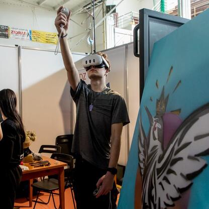 Młody człowiek w VR headset eksploruje wirtualną rzeczywistość na Festiwalu Zawodowca w Bielsku-Białej. (wygenerowano przez AI)