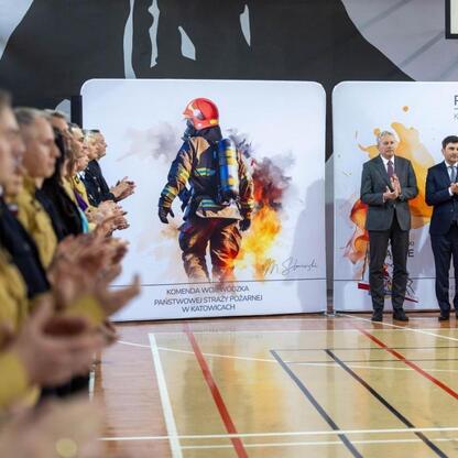 Wojciech Saługa, Marszałek Województwa Śląskiego, i Marek Wójcik, Silesia Voivode, składają cześć podczas ceremonii przekazania nowych wozów strażackich. (wygenerowano przez AI)