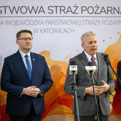 Wojciech Saługa, Marszałek Województwa Śląskiego, przemawia na konferencji prasowej w Komendzie Wojewódzkiej Państwowej Straży Pożarnej w Katowicach. (wygenerowano przez AI)