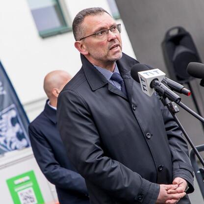 Mężczyzna przemawia na konferencji prasowej, omawiając pomoc w postaci sprzętu dla Ukrainy. (wygenerowano przez AI)