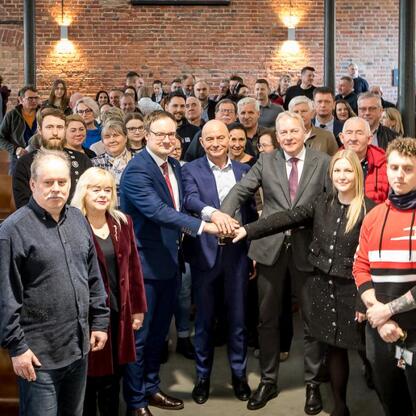 Wojciech Saługa, Marszałek Śląskiego, i Joanna Bojczuk, Członek Zarządu Województwa Śląskiego, wraz z Kamillem Żbikowskim, Prezydentem Zabrza, uczestniczą w uroczystości otwarcia Muzeum Górnictwa Węgl (wygenerowano przez AI)