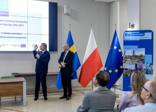Trzech mężczyzn w strojach formalnych omawiających projekty finansowane z Europejskich Funduszy dla Śląska 2021-2027. (wygenerowano przez AI)