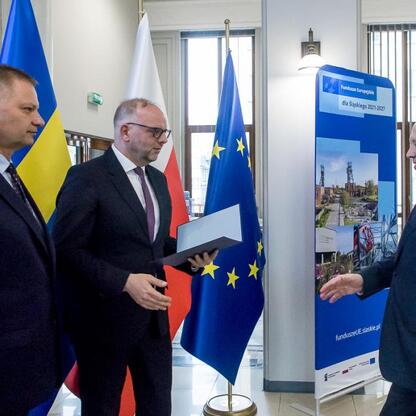 Trzech mężczyzn w strojach formalnych omawiających projekty finansowane z Europejskich Funduszy dla Śląska 2021-2027. (wygenerowano przez AI)
