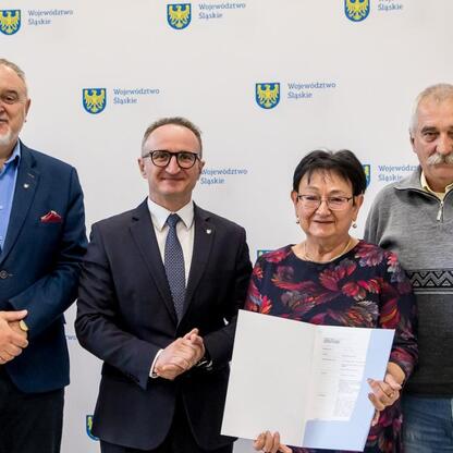Grzegorz Boski, wicemarszałek Województwa Śląskiego, wręcza dokumenty na modernizację rodzinnych ogrodów działkowych. (wygenerowano przez AI)