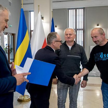 Grzegorz Boski, wicemarszałek Śląskiego, wręcza dokumenty radnemu Marekowi Bieniekowi, reprezentującemu Sejmik. (wygenerowano przez AI)