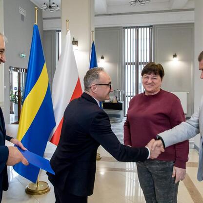 Wicemarszałek Grzegorz Boski i radny Marek Bieniek wręczają dokumenty na modernizację rodzinnych ogrodów działkowych. (wygenerowano przez AI)