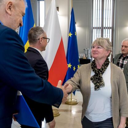 Wicemarszałek Grzegorz Boski i radny Marek Bieniek wręczają dokumenty działkom z finansowym wsparciem na modernizację ogrodów w Silesia. (wygenerowano przez AI)