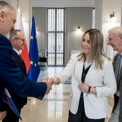 Wicemarszałek Grzegorz Boski wręcza dokumenty działkom działkowcom podczas ceremonii wsparcia rodzinnych ogrodów działkowych w Śląskim. (wygenerowano przez AI)