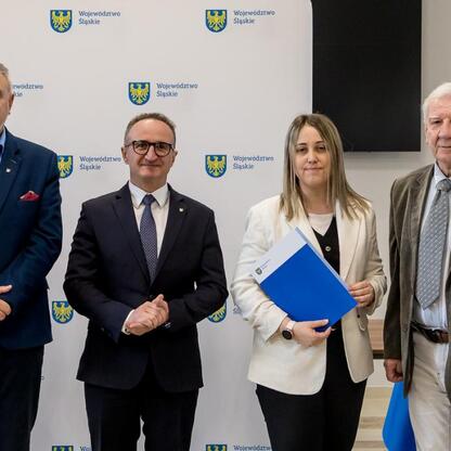 Wicemarszałek Grzegorz Boski wręcza dokumenty działkom z modernizacji ogrodów województwa śląskiego. (wygenerowano przez AI)