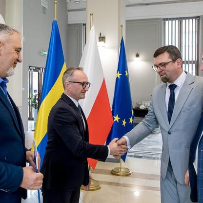 Wicemarszałek Grzegorz Boski i Marek Bieniek podczas ceremonii wręczenia dokumentów o modernizacji rodzinnych ogrodów działkowych. (wygenerowano przez AI)