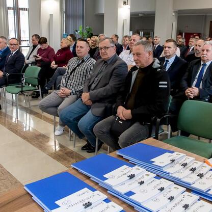 Wicemarszałek Grzegorz Boski przekazuje finansowe wsparcie dla modernizacji rodzinnych ogrodów działkowych. (wygenerowano przez AI)